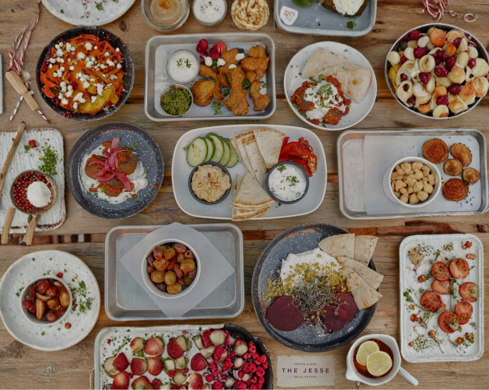 An overhead spread of Mediterranean dishes from The Jesse Restaurant in Reno, including dips, salads, and small plates arranged on a rustic table.